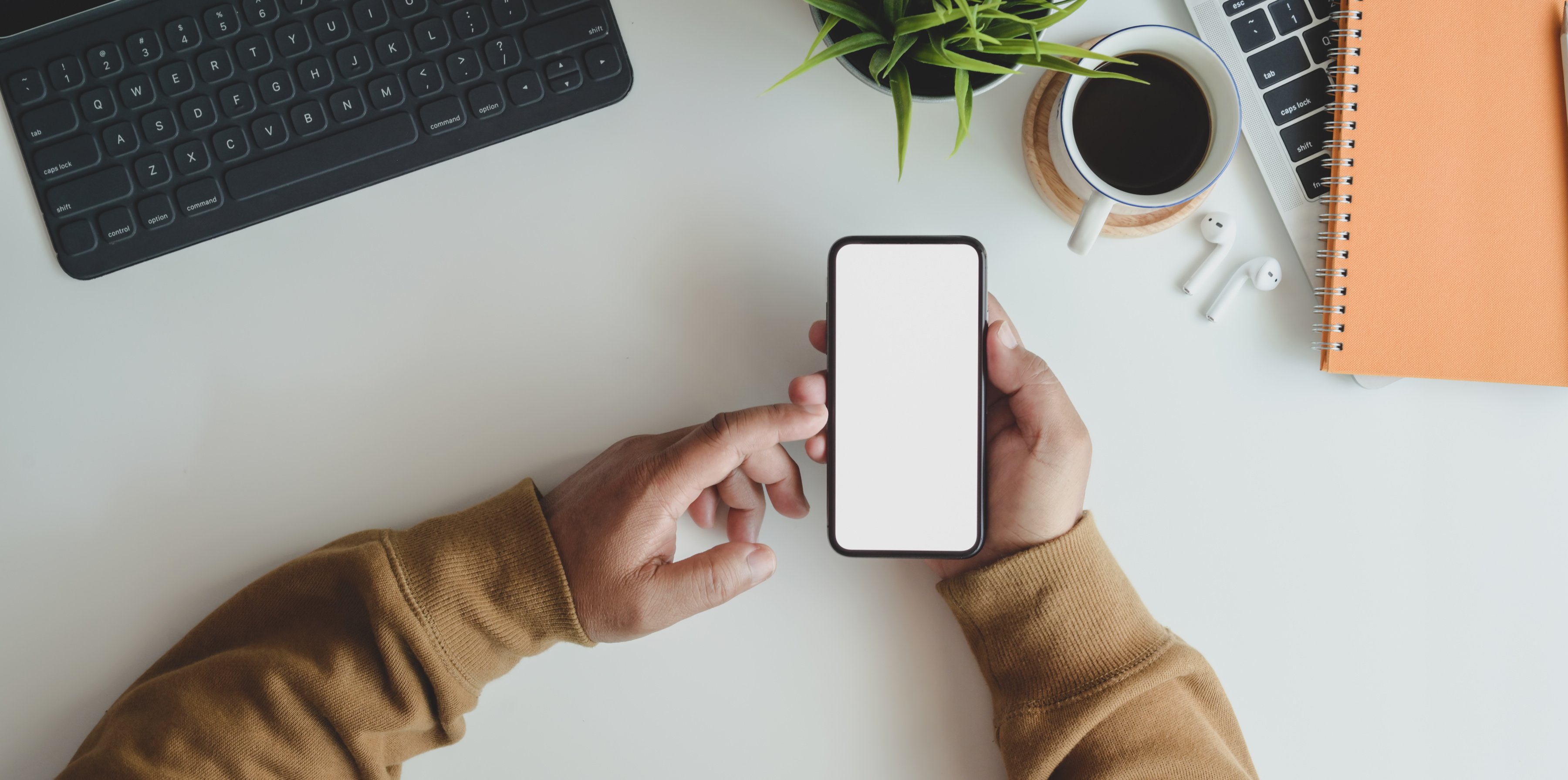 Anonymous man using phone at working desk